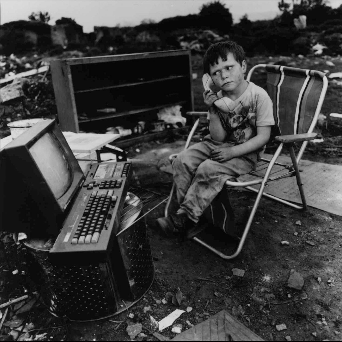 A little boy creates his own fantasy game amid his junky surroundings, in this photograph by Mary Ellen Mark, "Paddy Joyce. Travellers Encampment at Funglas, Ireland, 1991." The photograph is among 150 on show in a current exhibition, "The Magic of Play." (AP Photo/Kreisberg Group Ltd. /Mary Ellen Mark)